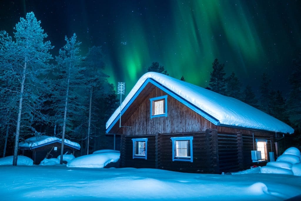 log cabin under the northern lights in lapland